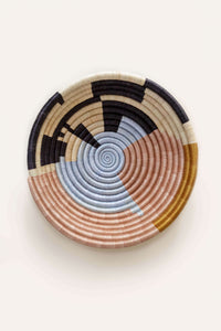 Woven basket with abstract circle pattern on a white background