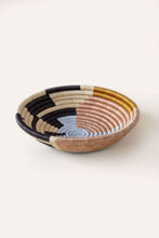 Woven african basket with neutral multi colored pattern on a white background