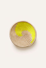 Round woven basket with neon yellow spiral pattern on a white background