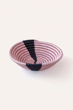 Pink woven basket with black accents on a white background