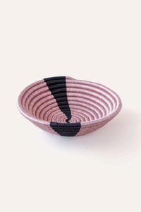 Pink woven basket with black accents on a white background