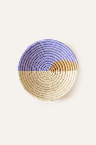 Round woven basket with purple and beige pattern on a white background