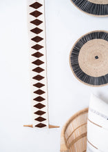 Decorative wall hanging with geometric pattern on a white background