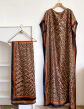 Silky Kaftan with geometric pattern on hangers against a white wall