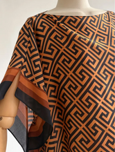 Mannequin wearing a patterned kaftan with a geometric design.