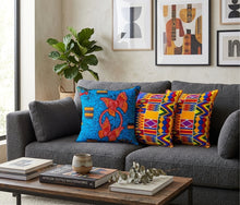 Gray sofa with colorful African pillows and a wooden coffee table in a living room setting.