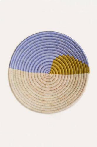 Round woven basket with blue, beige, and yellow color pattern on a white background