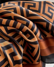 Close-up of a patterned kaftan dress fabric with black and beige geometric design