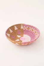 Woven African basket with pink and brown pattern on a white background