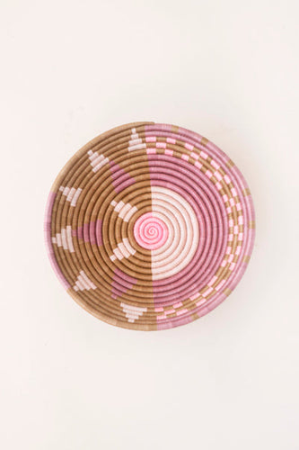 Woven basket with pink and brown pattern on a white background