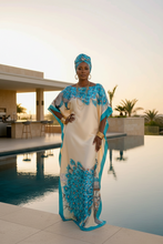 Woman in a blue and white dress standing by a pool with a modern building in the background.