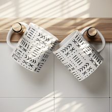 2 white coffee mugs with black African pattern hung on hooks