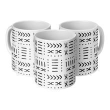 three white ceramic coffee mugs with black abstract African patterns