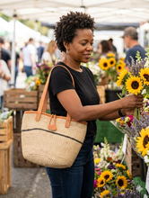 Woman shopping at a farmer's market with a straw bag