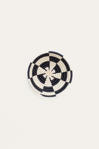 Black and white woven basket on a light beige background