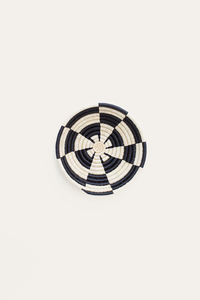 Black and white woven basket on a light beige background