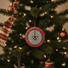 Decorative Christmas ornament with red and black pattern on a Christmas tree.