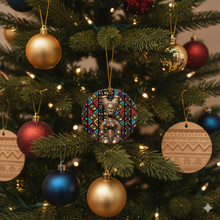 Decorative Christmas ornament with african art image hanging on a tree with other ornaments.
