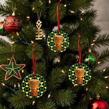 Decorative Christmas ornaments with drums and geometric patterns on a tree.