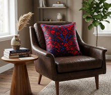 red blue african fabric pillow on a leather chair in a masculine styled room.