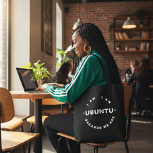 Woman sitting at a table with a laptop, wearing a black bag with 'Ubuntu' text.