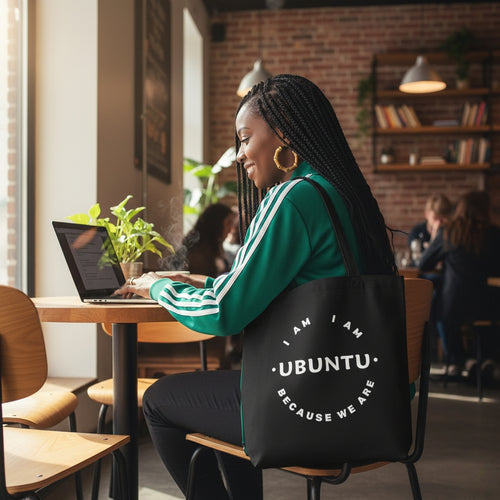 Woman sitting at a table with a laptop, wearing a black bag with 'Ubuntu' text.