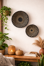 Decorative wall baskets on a wall with plants and a shelf below.