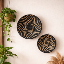 Decorative wall baskets on a wall with plants and a shelf below.