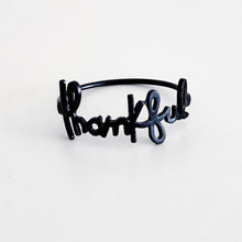 matte black metal napkin with the words thankful in cursive