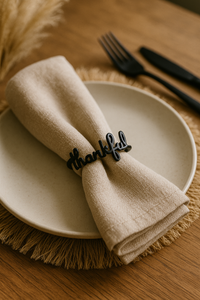 Napkin with 'thankful' clip on a plate with cutlery on a wooden table