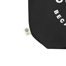 Black tote bag with a green organic certification label on a white background