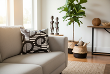 Living room with a beige sofa, decorative African pillow.