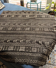 African textile with black and white mud cloth pattern on a blue chair