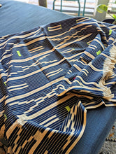 Striped fabric with blue, beige, and black pattern on a blue surface