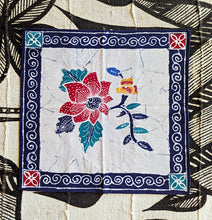 Decorative fabric square with floral design and decorative border on a textured background