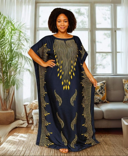 Woman wearing a long, dark blue kaftan dress with gold patterns in a living room.
