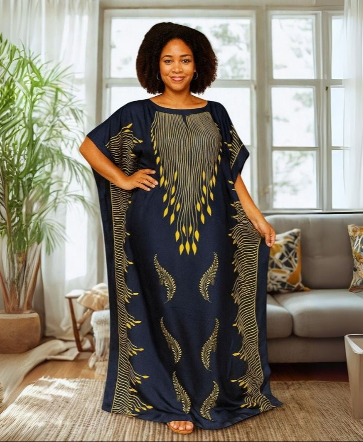 Woman wearing a long, dark blue kaftan dress with gold patterns in a living room.