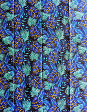 Tropical leaf pattern fabric with blue, green, and yellow colors on a black background.