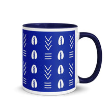 A blue and white ceramic coffee mug with a traditional African mud cloth pattern design.