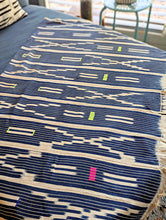 Textile with blue and beige pattern on a bed