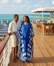 Man and woman on a cruise ship deck with ocean view. She's wearing a blue, flowy kaftan dress.