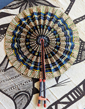 Decorative fabric wall fan with geometric pattern on a textured surface
