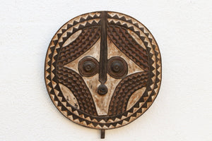 Decorative african wooden mask with intricate patterns on a white background