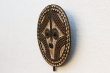 Wooden mask with intricate carvings on a white background