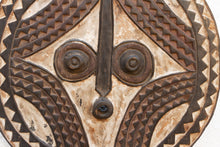 Close-up of a decorative metal shield with tribal patterns