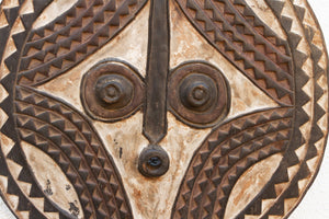 Close-up of a decorative metal shield with tribal patterns