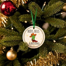 Christmas ornament with 'Boots, Bells & Blessings' text and cactus design on a decorated tree.