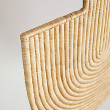 Close-up of a woven african wall art on a plain background