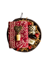 Decorative basket with a heart-shaped bottle stopper, red patterned towel, and other decorative items on a white background