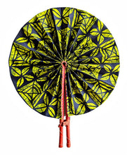 A round folding hand fan with a vibrant yellow and black leaf pattern, held open by red plastic handles against a plain white background.